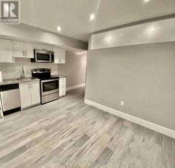Toronto (South Riverdale) house for rent - A kitchen with a microwave above the stove and a counter with a sink.