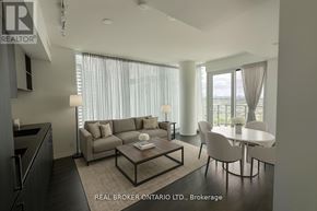 Vaughan (Vaughan Corporate Centre) condo for rent - A modern living room with a grey sofa, a coffee table, and a dining table with chairs.