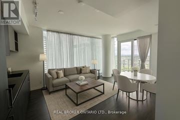 Vaughan (Vaughan Corporate Centre) condo for rent - A modern living room with a grey sofa, a coffee table, and a dining table with chairs.