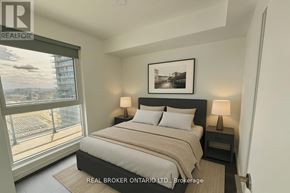 Vaughan (Vaughan Corporate Centre) condo for rent - A bedroom with a large bed and a view of the city.