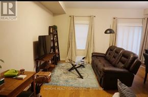 Kitchener townhouse for rent - A living room with a brown leather couch and a wooden coffee table.