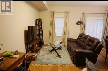 Kitchener townhouse for rent - A living room with a brown leather couch and a wooden coffee table.