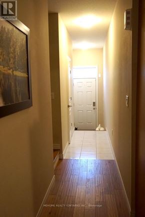 Kitchener townhouse for rent - A hallway with a door at the end and a painting on the wall.
