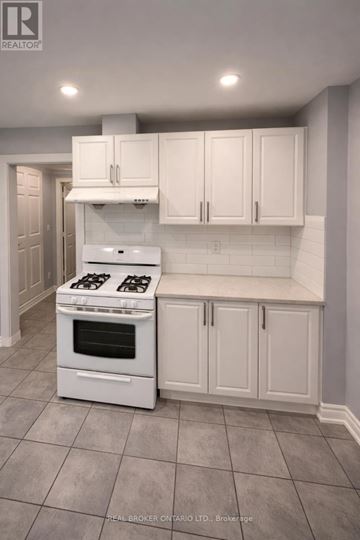 London North (North N) triplex for rent - A white kitchen with a stove and cabinets.