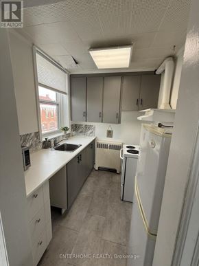 Brampton (Downtown Brampton) condo for rent - A small, clean kitchen with white appliances and cabinets.