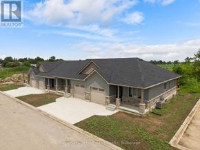 Huron East (Seaforth) townhouse for rent - A large, two-story house with a grey roof and a large front yard.