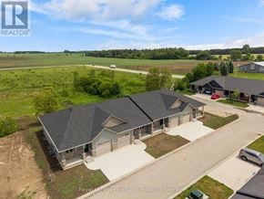 Huron East (Seaforth) townhouse for rent - A large, modern house with a grey roof and a large front yard is for sale.
