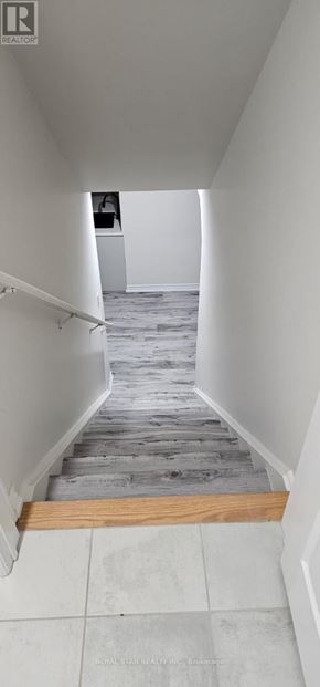 Oshawa (Eastdale) house for rent - A hallway with a wooden floor and white walls.