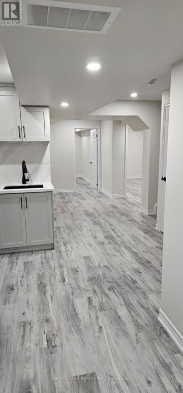 Oshawa (Eastdale) house for rent - A kitchen with white cabinets and a wooden floor.
