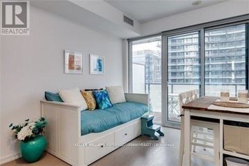 Toronto (Waterfront Communities) condo for rent - A living room with a blue couch and a green vase.