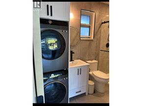 Coquitlam house for rent - A washing machine is in the left part of the image and a toilet is in the right part of the image.