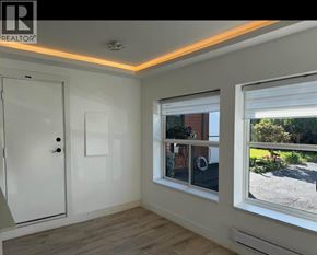 Coquitlam house for rent - A room with a white door, a window, and a wooden floor.