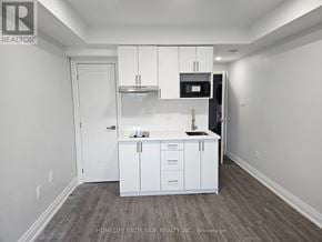 Toronto (Birchcliffe-Cliffside) house for rent - A real estate listing photo of a room with white cabinetry and a wood floor.