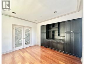 Vancouver house for rent - A room with wooden floors and black cabinets.