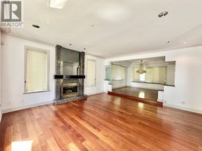 Vancouver house for rent - A spacious living room with hardwood floors and a fireplace.