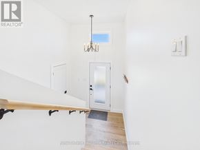 Kincardine house for rent - A chandelier hangs over a staircase with a glass door leading to a balcony.