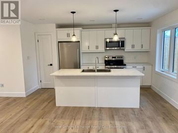 Kincardine house for rent - A kitchen with white cabinets and a wooden floor.