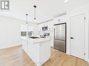 Kincardine house for rent - A spacious kitchen with wooden floors and white cabinetry.