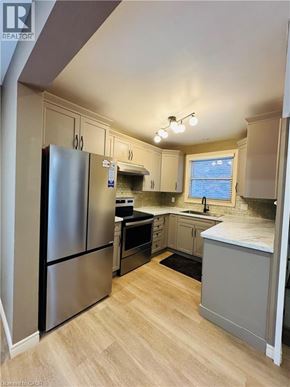 Niagara Falls house for rent - A kitchen with a refrigerator, sink, and cabinets.