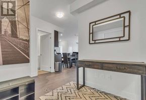 Oshawa (Windfields) condo for rent - A modern living room with a large mirror and a dining area in the background.