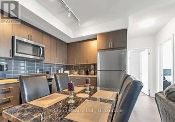 Oshawa (Windfields) condo for rent - A modern kitchen with a dining table set for four.