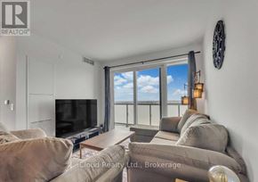 Oshawa (Windfields) condo for rent - A living room with a flat screen TV and a large window with a view of the sky.