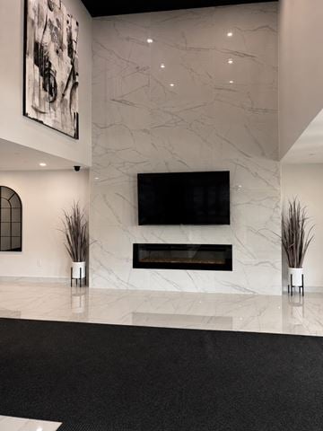 Moncton apartment for rent - A modern living room with a fireplace and a large painting on the wall.