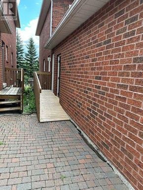 Newmarket (Stonehaven-Wyndham) house for rent - A red brick wall with a wooden door and steps leading to it.