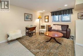 Newmarket (Stonehaven-Wyndham) house for rent - A living room with a brown leather couch, a wooden coffee table, and a rug.