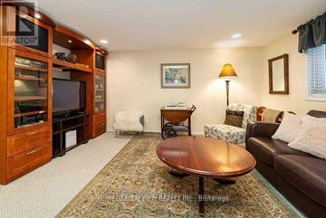 Newmarket (Stonehaven-Wyndham) house for rent - A living room with a brown leather couch and a wooden coffee table.
