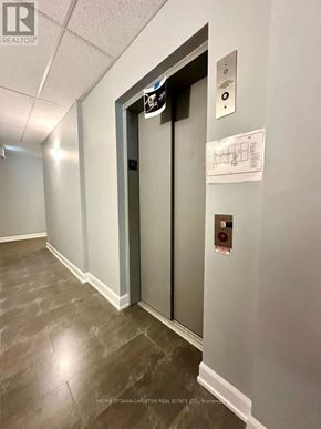 Ottawa condo for rent - A hallway with a metal door and a sign on the wall.