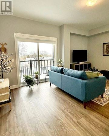 Ottawa condo for rent - A blue couch sits in a living room with a television and sliding glass doors.