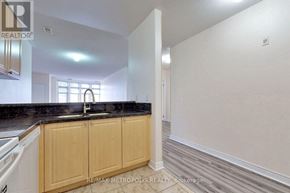 Markham (Middlefield) condo for rent - A kitchen with wooden cabinets and a black countertop.