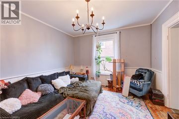 Brantford house for rent - A living room with a black sofa and a chandelier.