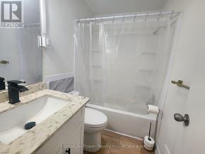 For rent in Kitchener - A white bathroom with a marble counter top and a glass shower enclosure.