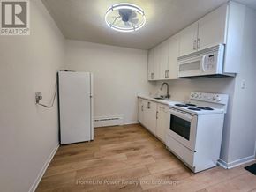 For rent in Kitchener - A kitchen with white appliances and cabinets.