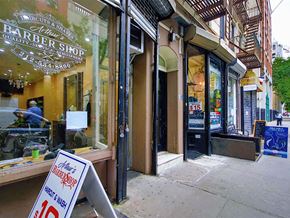 New York apartment for rent - a sign outside of a barber shop on the sidewalk