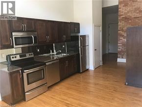 Hamilton condo for rent - A kitchen with wooden cabinets and stainless steel appliances.