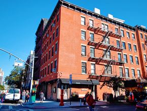 New York apartment for rent - a red brick building on the corner of a city street
