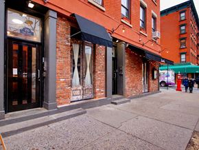New York apartment for rent - a city street with a red brick building and a sidewalk
