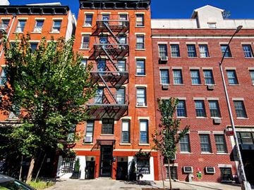 New York apartment for rent - a red brick apartment building with a fire escape