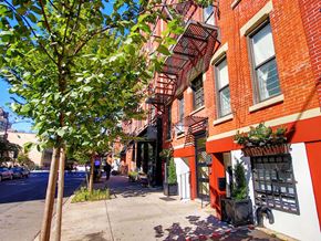 New York apartment for rent - a city street with red brick buildings and trees