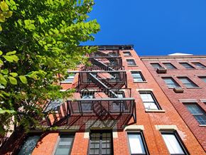New York apartment for rent - a fire escape on the side of a brick building
