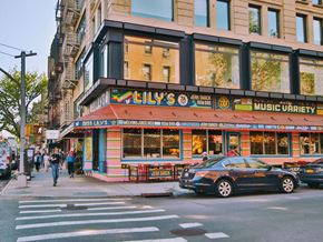 New York apartment for rent - a car parked in front of a music store on a city street