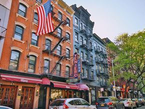 New York apartment for rent - a city street with cars and buildings and an flag
