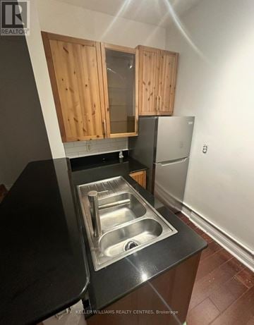 Toronto (Cabbagetown-South St. James Town) duplex for rent - A kitchen with a sink and wooden cabinets.
