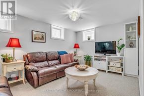 Mississauga (Mississauga Valleys) house for rent - A living room with a brown leather couch, a white coffee table, and a flat screen TV.