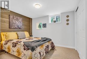 Mississauga (Mississauga Valleys) house for rent - A bedroom with a floral bedspread and a window with a view of trees.