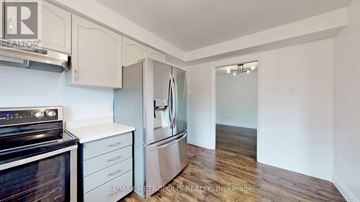 Barrie (Ardagh) house for rent - A kitchen with a black stove top oven and white cabinets.