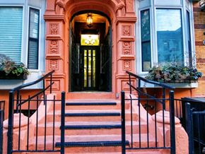New York apartment for rent - the front door of a house with steps and a black gate